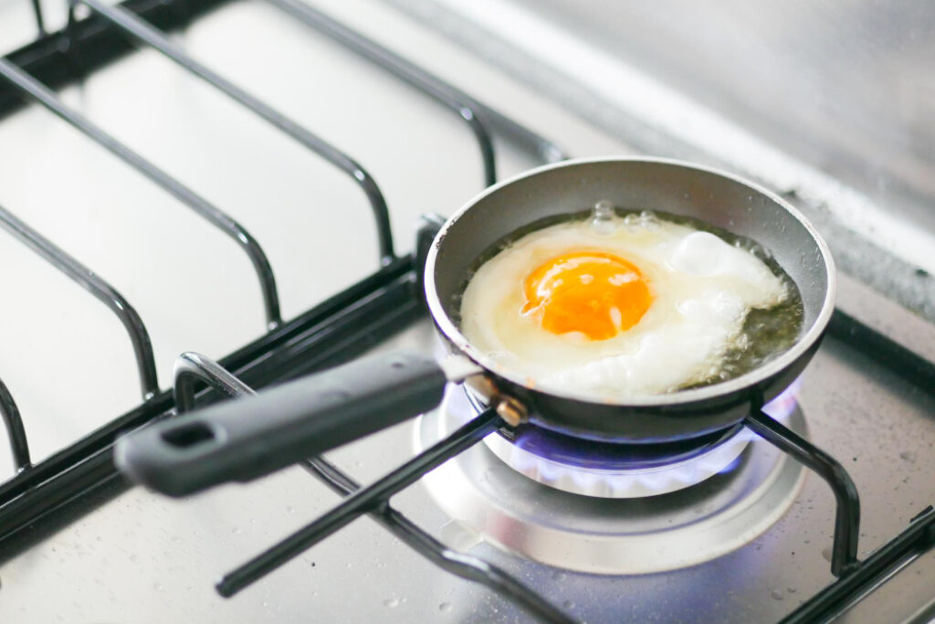 Frigideira pequena para um ovo sendo frito em um fogão a gás